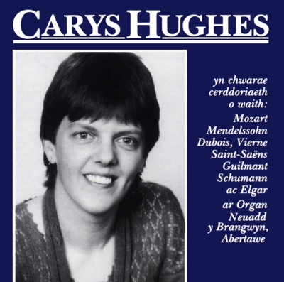 A black-and-white smiling portrait sits beneath the large white title “Carys Hughes”, beside a column of Welsh text on a navy-blue cover.
